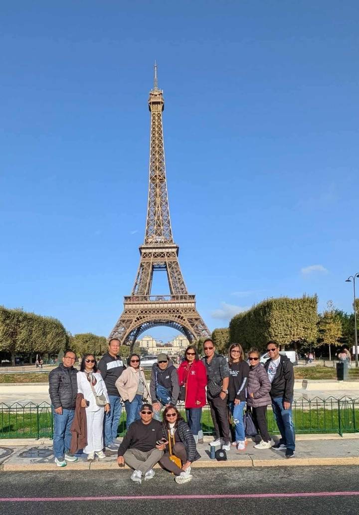 Groupe de personnes avec la tour Eiffel en arrière-plan.