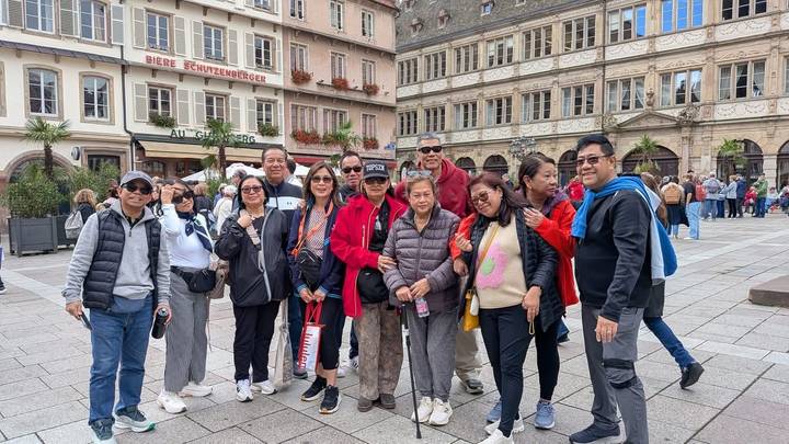 Des gens qui posent sur une place historique d'une ville européenne.