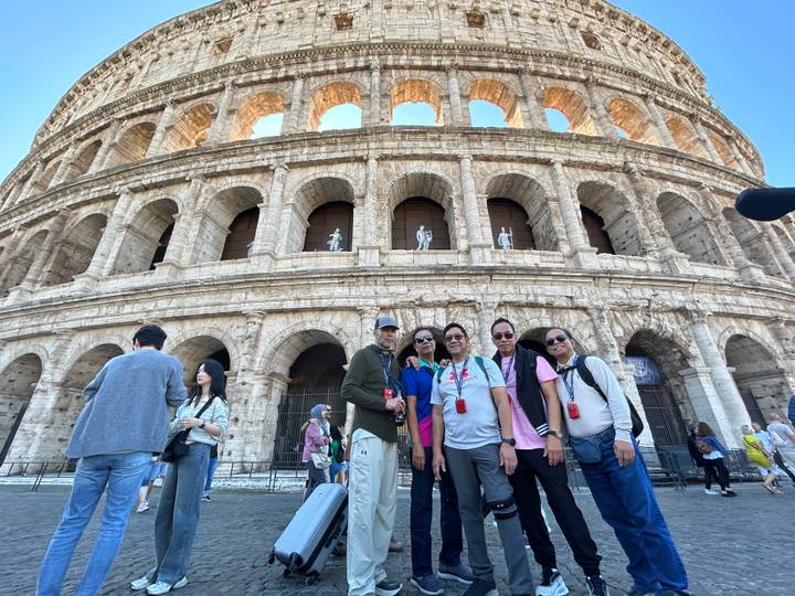 Groupe de personnes posant devant le Colisée.
