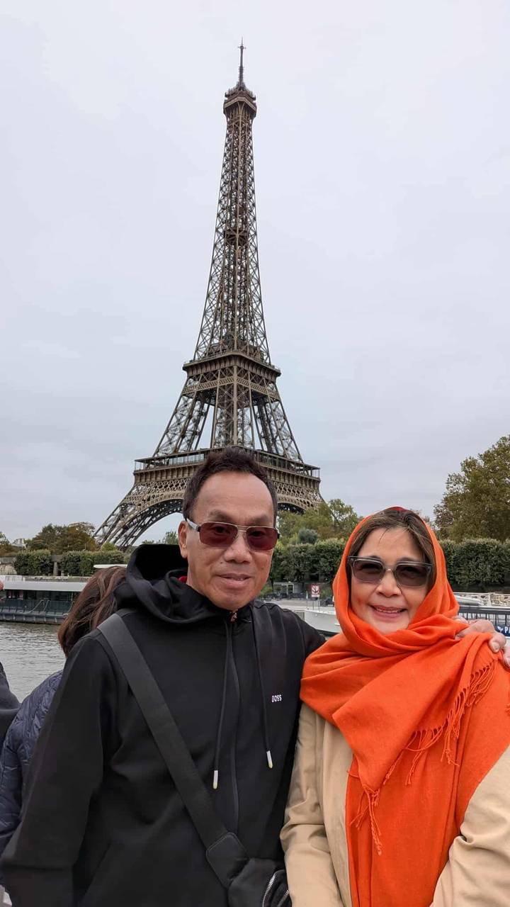 Couple posant avec la tour Eiffel en arrière-plan.