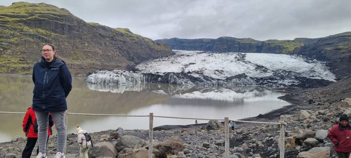Lac de glacier avec des personnes debout au bord du rivage.