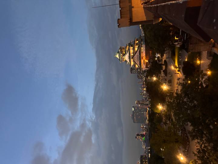 Vista del Castillo de Osaka iluminado por la noche con las luces de la ciudad alrededor.