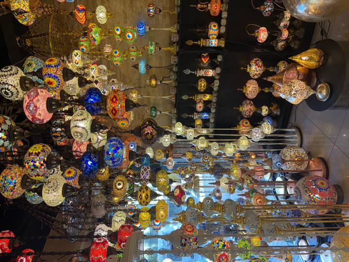 Pièce remplie de lampes et lanternes colorées aux motifs complexes.