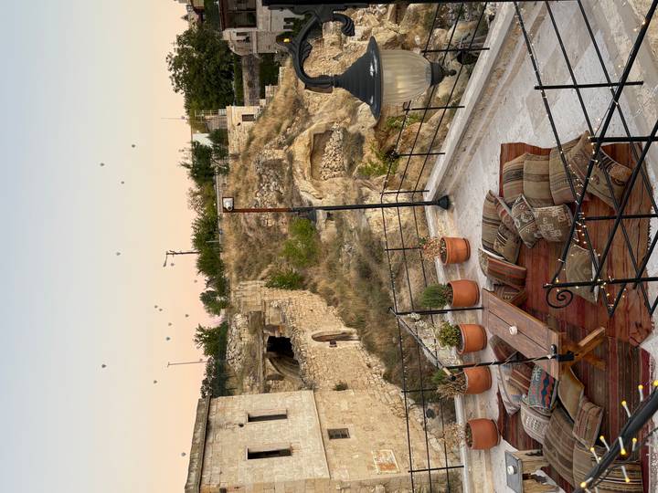 Terrasse avec coussins donnant sur un paysage avec des montgolfières.