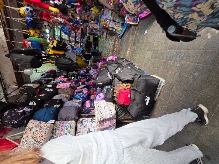Étal de marché rempli de divers sacs à dos et sacs.
