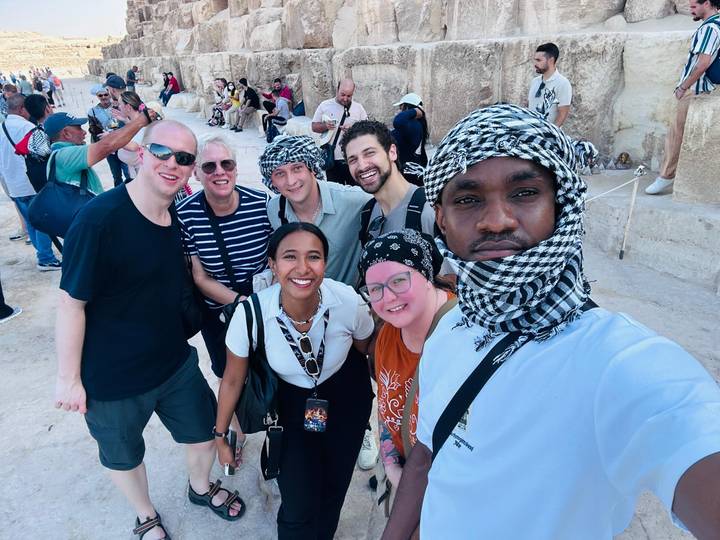 Selfie de groupe de touristes souriants en foulards traditionnels.