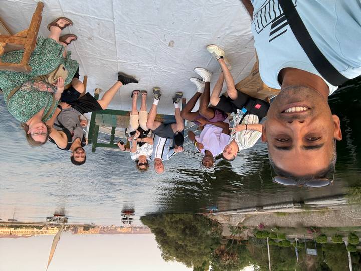 Groupe d'amis sur un bateau sur une rivière avec des vues lointaines.