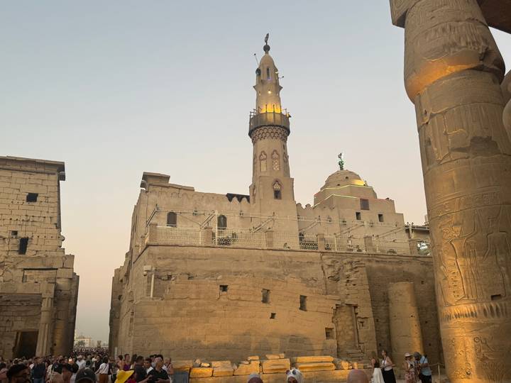Architecture islamique avec un minaret et des dômes au crépuscule.