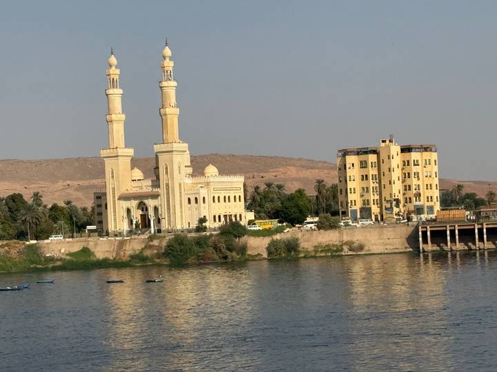 Mosquée avec des minarets jumeaux au bord d'une rivière.