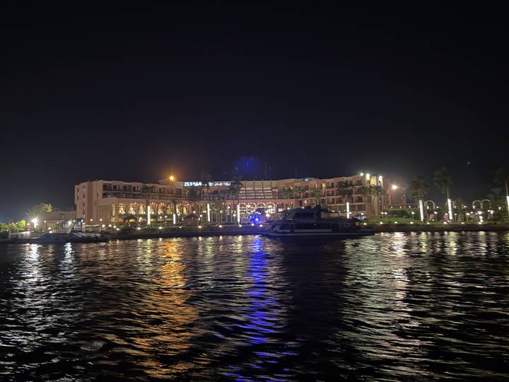 Bâtiment d'hôtel illuminé la nuit se reflétant dans l'eau.