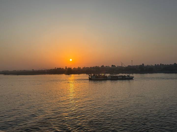 Bateau naviguant sur une rivière au coucher du soleil.
