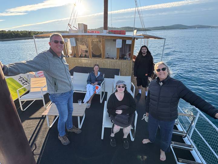 Quatre personnes se détendant sur le pont d'un bateau en mer.