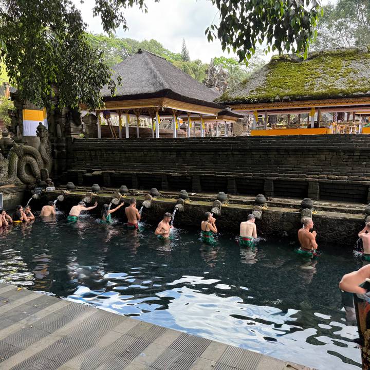 Des personnes participant à un bain rituel en plein air.