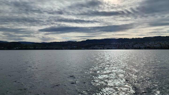 Vue sur une grande étendue d'eau avec un horizon vallonné.