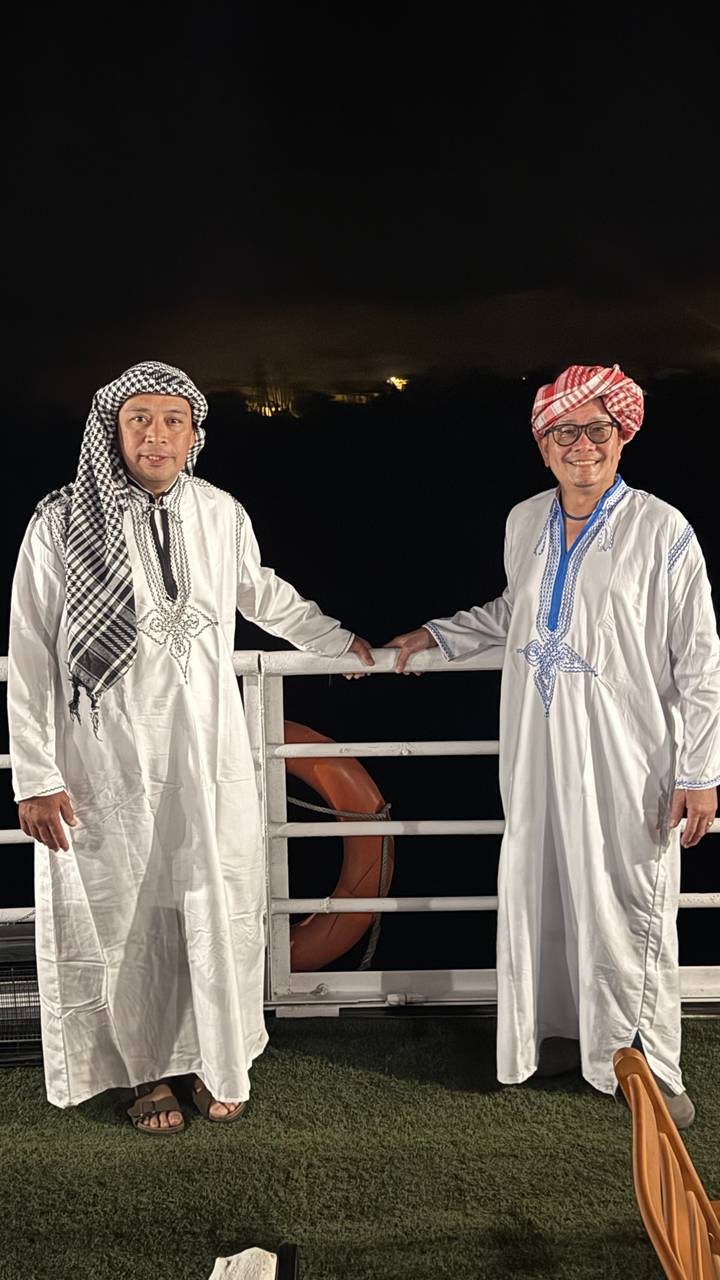 Deux personnes vêtues de vêtements traditionnels la nuit.