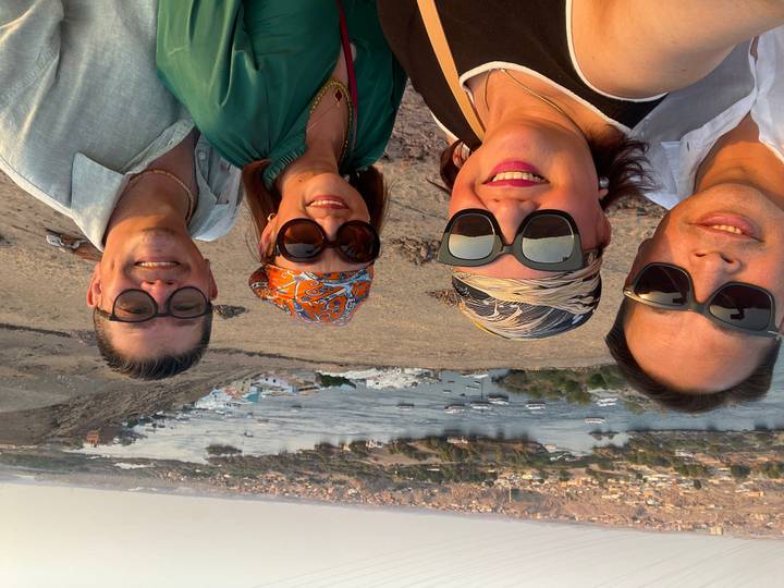 Quatre personnes prenant un selfie avec une vue panoramique sur la rivière.