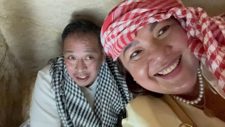 Gros plan de deux personnes souriantes, portant des foulards traditionnels.