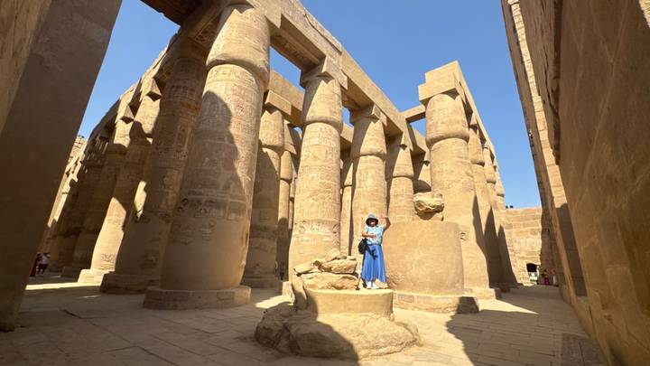 Un temple antique avec de massives colonnes de pierre et des hiéroglyphes.