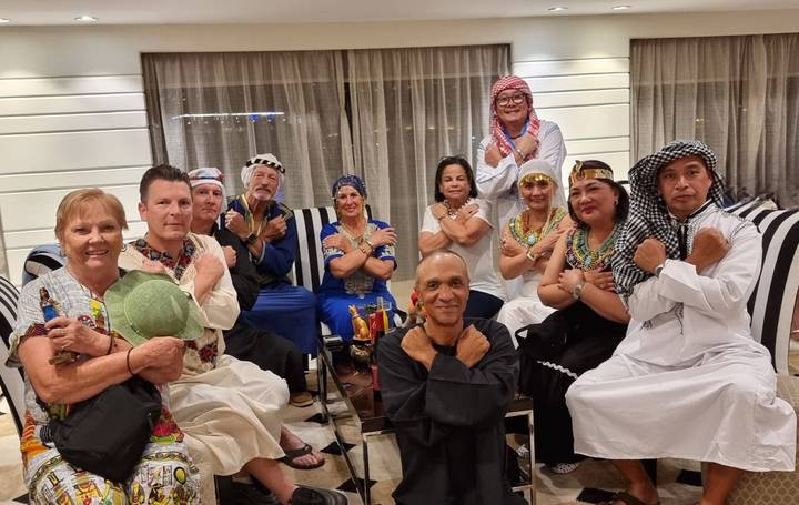 Groupe de personnes vêtues de vêtements traditionnels du Moyen-Orient à l'intérieur.