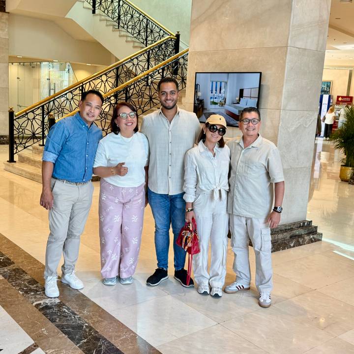 Cinq personnes qui posent dans le hall d'un hôtel.