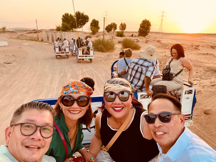 Groupe de personnes lors d'un safari dans le désert au coucher du soleil.