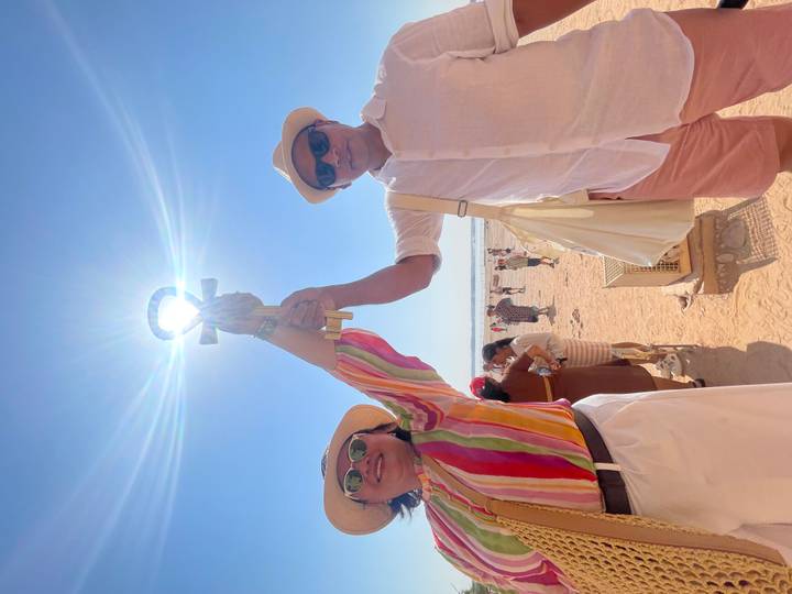 Couple tenant des symboles égyptiens ankh avec un ciel ensoleillé lumineux.