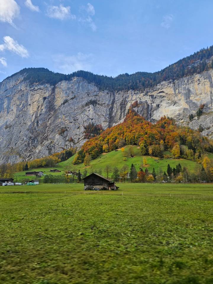 Bergachtig landschap met herfstkleuren en rustieke chalets.