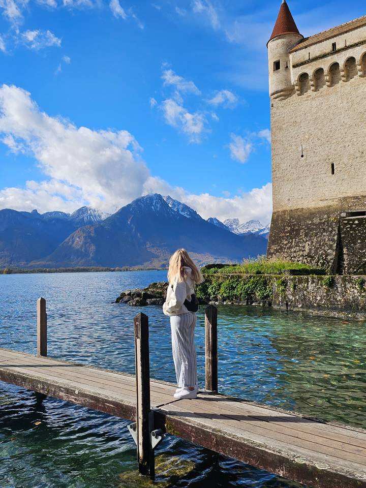 Persoon die een groot meer met bergen op de achtergrond bewondert.