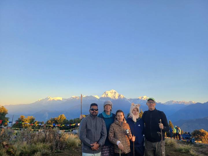 Un groupe de personnes avec une toile de fond de montagne au lever du soleil.