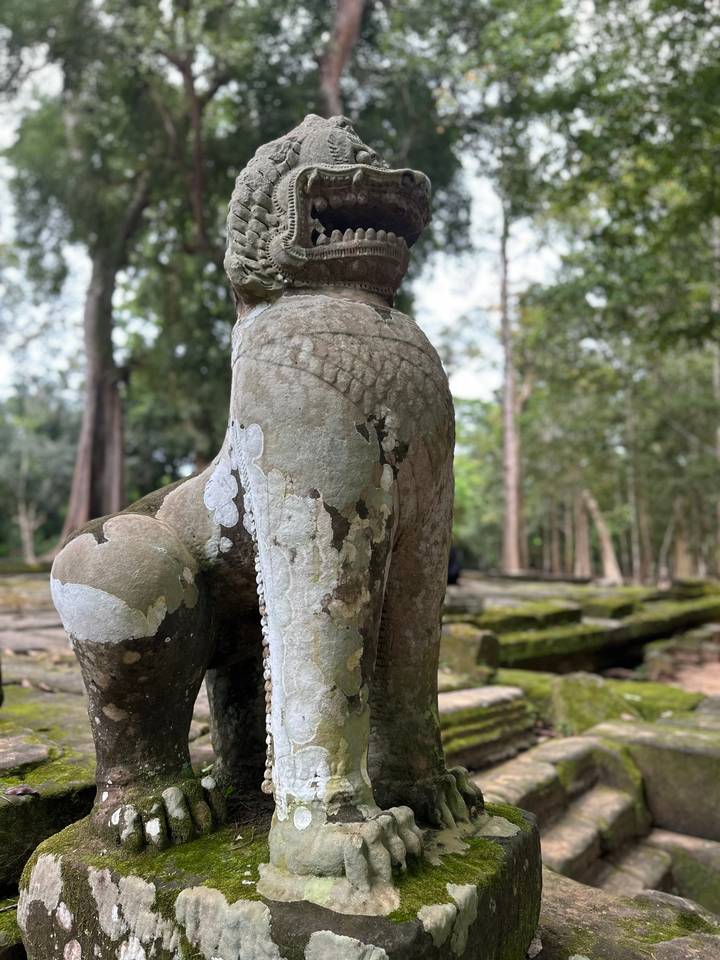 Gros plan d'une statue ancienne avec un arrière-plan forestier