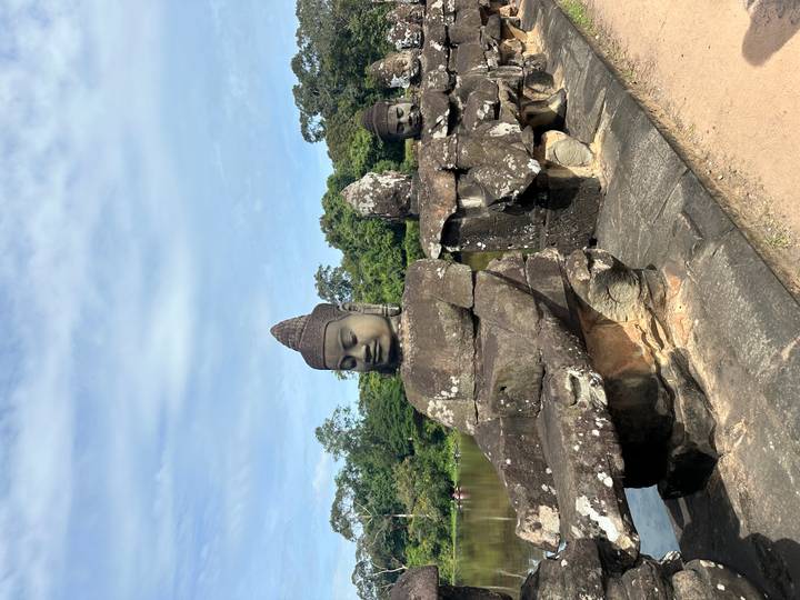Rangée de statues de pierre aux expressions sereines dans un cadre historique