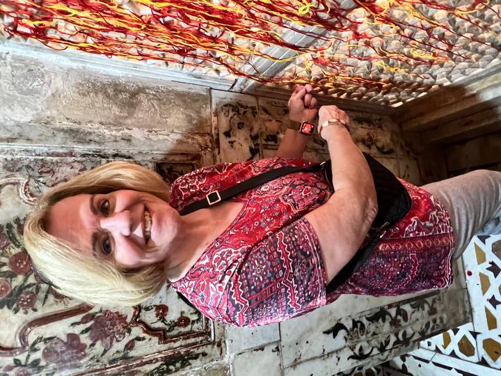 Person at an ornate wall decorated with intricate patterns.