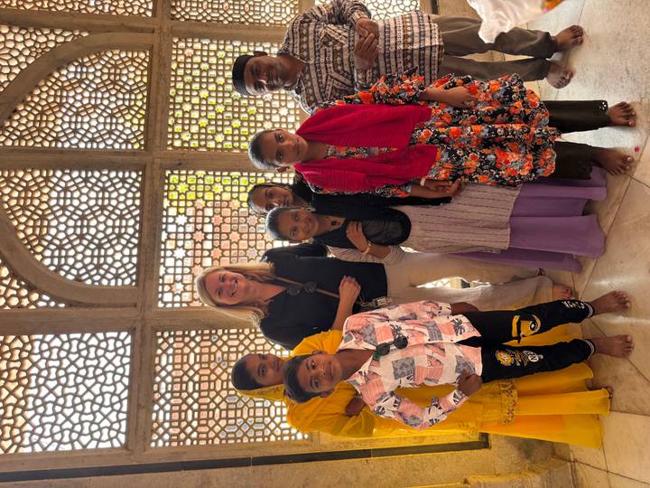 Person posing with local children in traditional clothing.