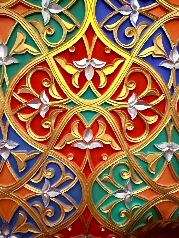 Motif complexe de sculptures ornementales colorées.