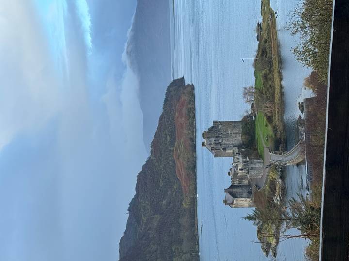 Vue panoramique du château d'Eilean Donan par une journée avec des nuages dramatiques.