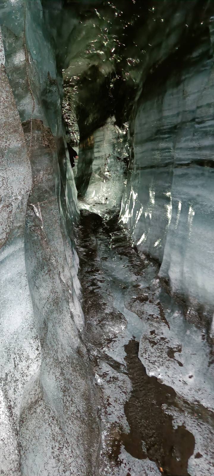 Interior of an ice cave with slick walls.