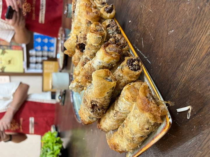 Teller mit gekochten Frühlingsrollen auf einem Tisch.