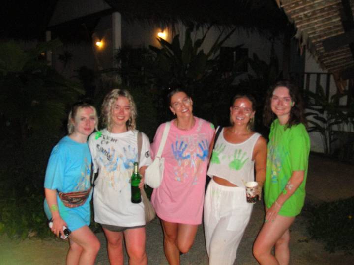 Groep vrienden met beschilderde shirts bij een nachtelijk evenement.