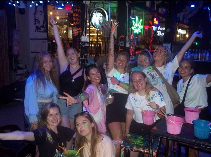 Groep die plezier heeft bij een nachtelijk evenement met neonverf.