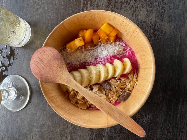 Kom fruit en granola met een houten lepel.