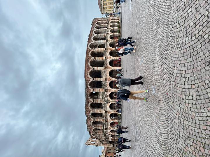 Toeristen bij een historisch Colosseum-achtig monument.