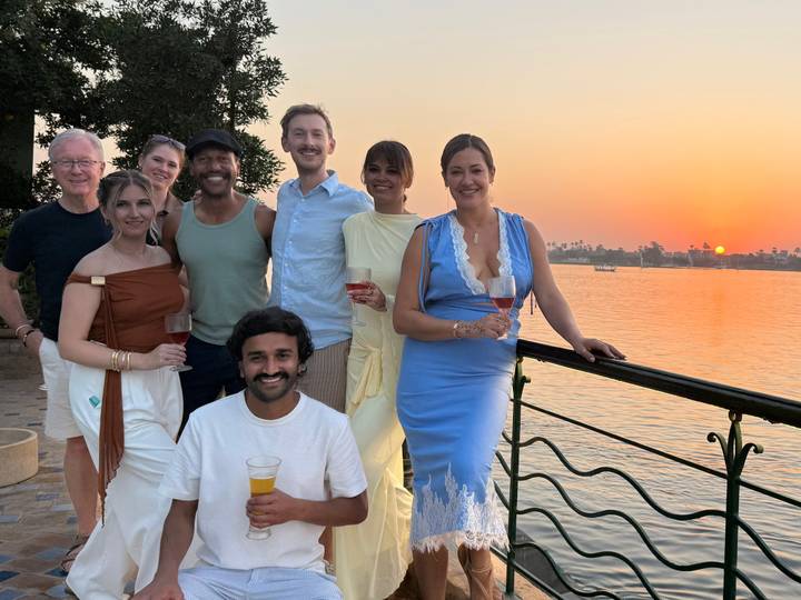Group of people posing at sunset by the river.