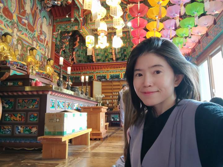 Persoon die een selfie maakt in een kleurrijke tempel.