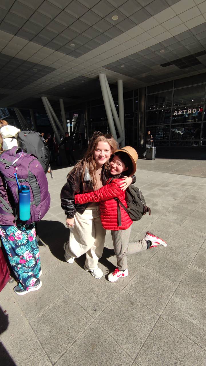 Twee vrienden die elkaar omhelzen op een reislocatie.