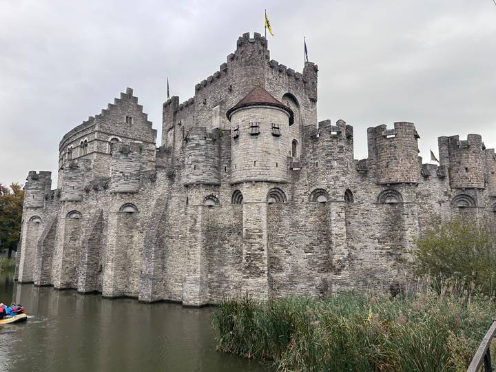 Eine mittelalterliche Burg mit Steinmauern, die neben Wasser liegt.