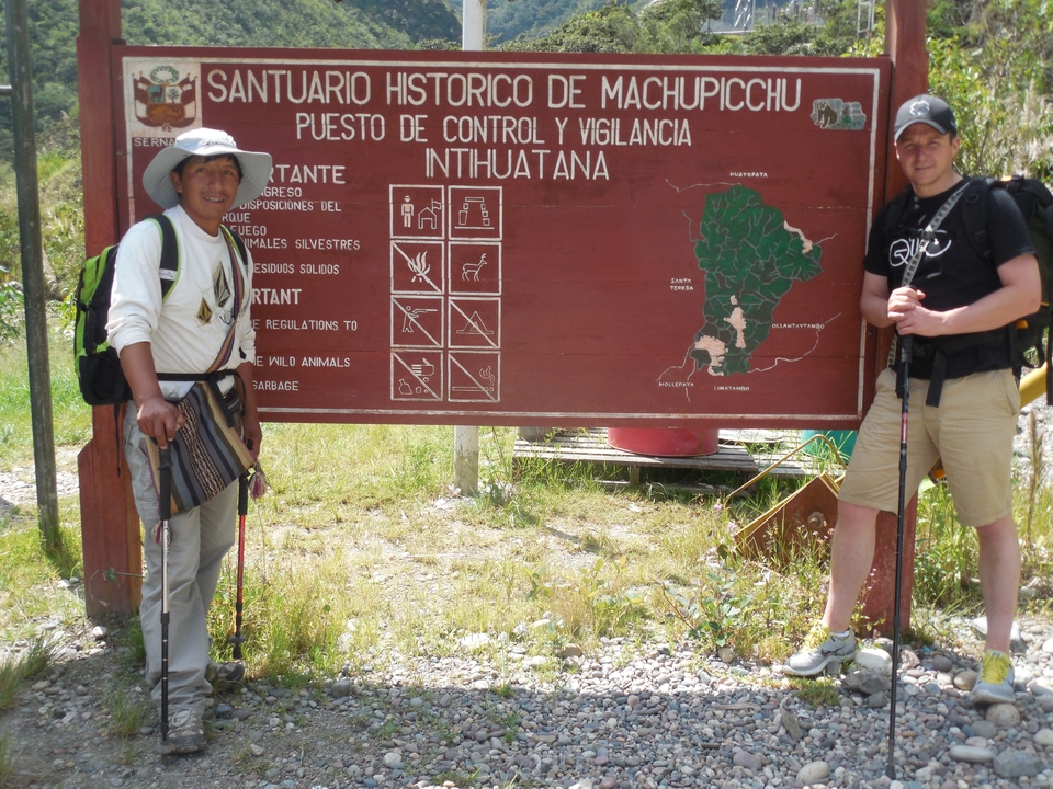 Deux hommes à côté d'un panneau dans un parc national.
