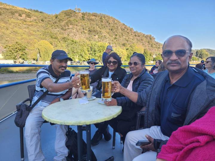 People enjoying drinks on a boat with a scenic backdrop