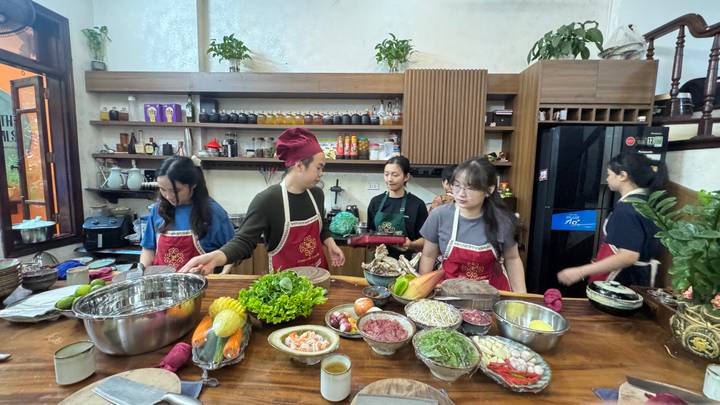 Group preparing dishes in a cooking class setting.