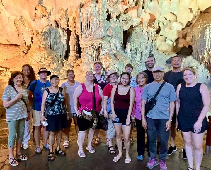 Gruppe von Menschen in einer Höhle mit Stalaktiten.
