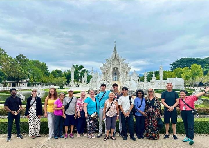 Gruppe vor einem weißen Tempel.